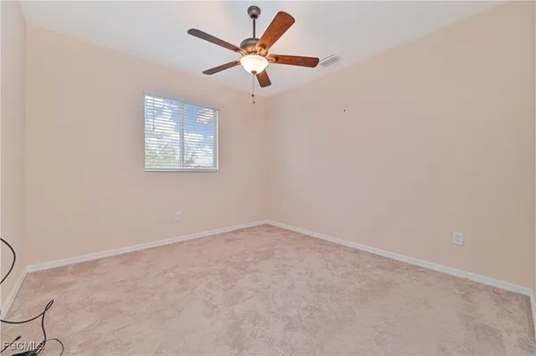 an empty room with a window and a ceiling fan
