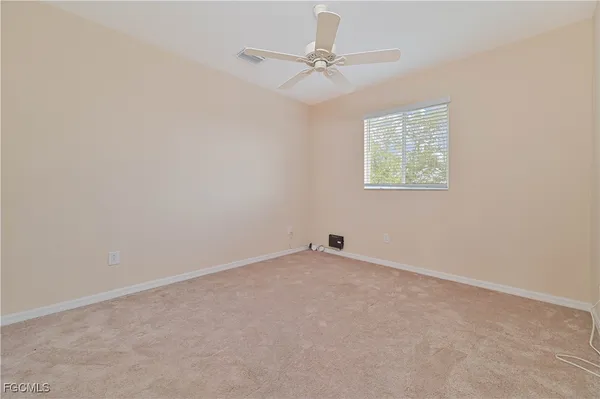 an empty room with a window and a fan