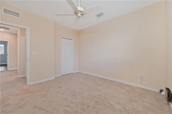 an empty room with a ceiling fan and a window