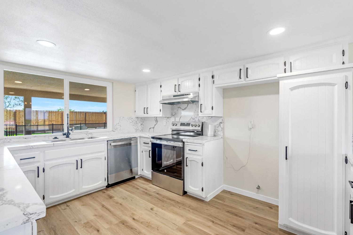 16860 Mark Road Madera, CA 93636 - Photo 12 of 44 a kitchen with stainless steel appliances granite countertop a stove a sink and a refrigerator