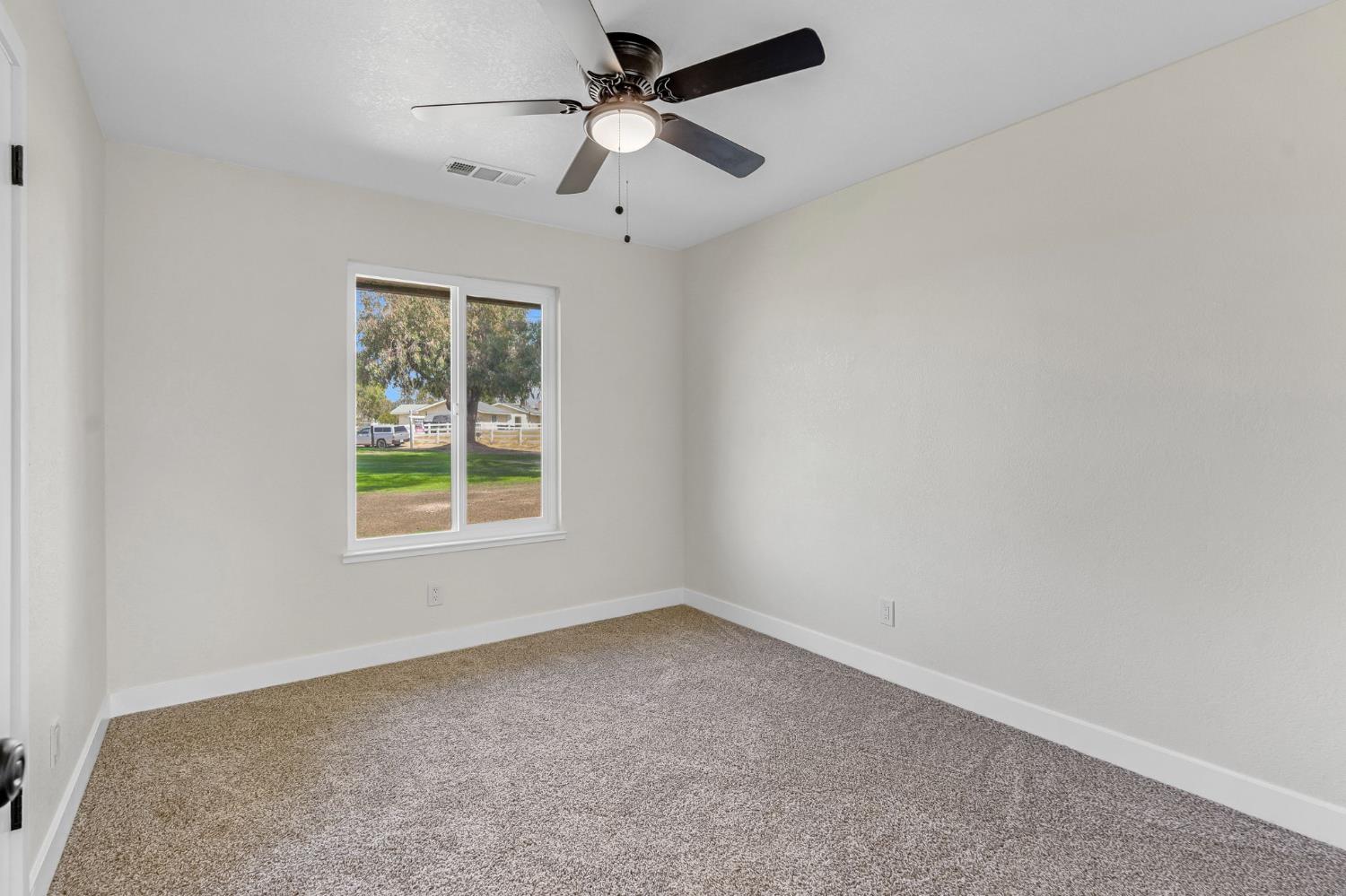16860 Mark Road Madera, CA 93636 - Photo 23 of 44 an empty room with a window and a fan