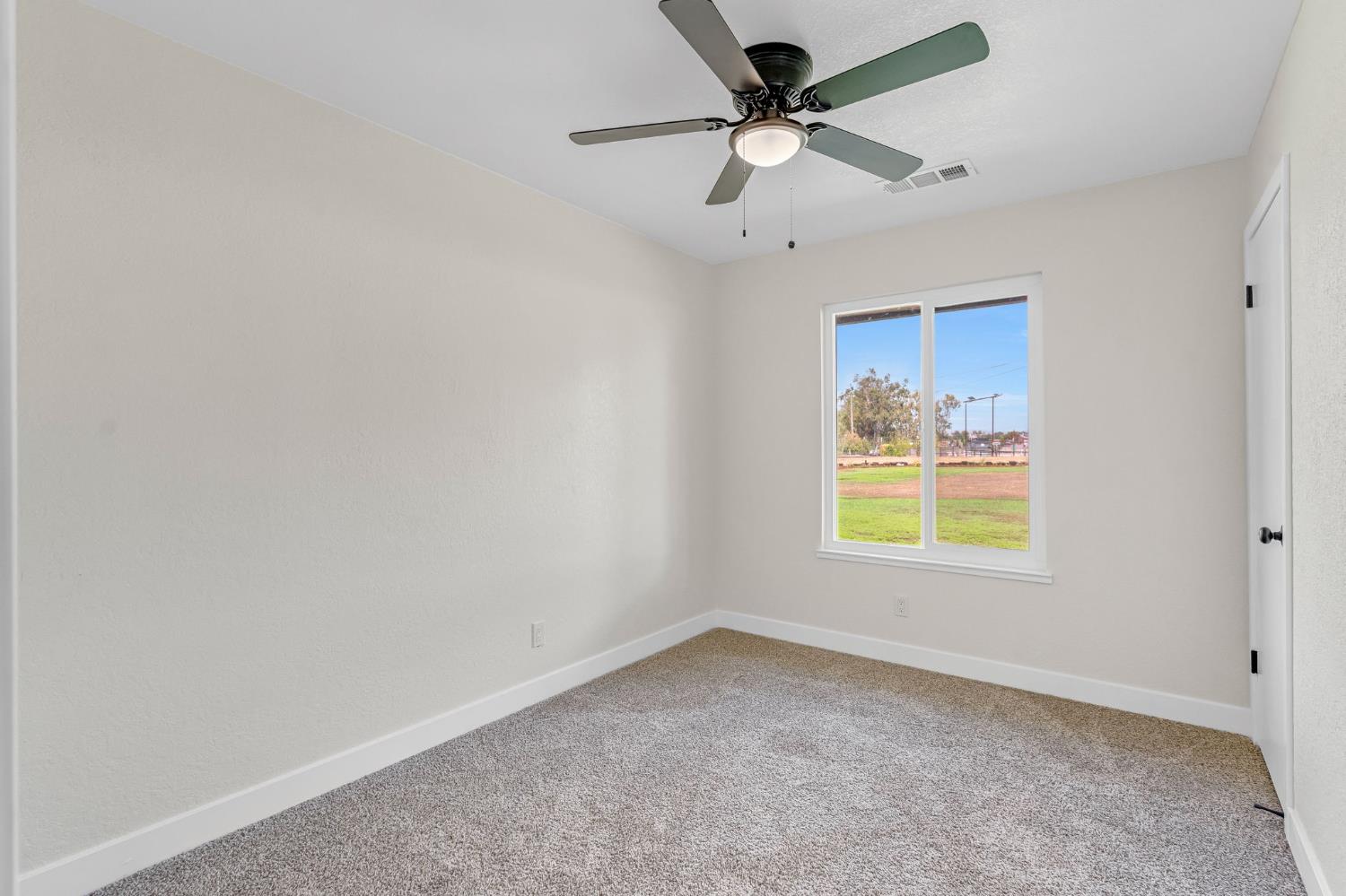 16860 Mark Road Madera, CA 93636 - Photo 24 of 44 an empty room with a window and a fan