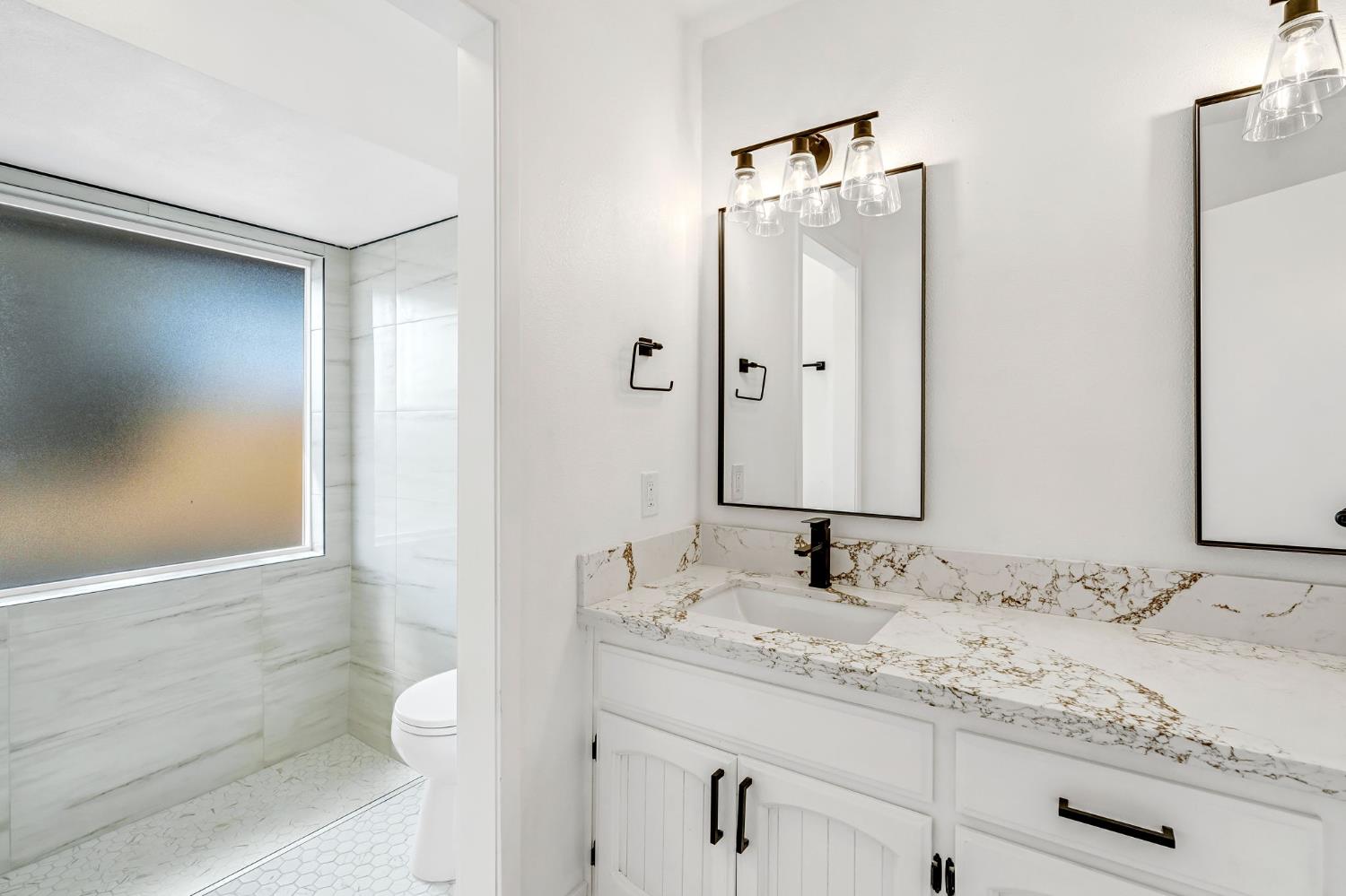 16860 Mark Road Madera, CA 93636 - Photo 28 of 44 a bathroom with a granite countertop sink toilet and shower