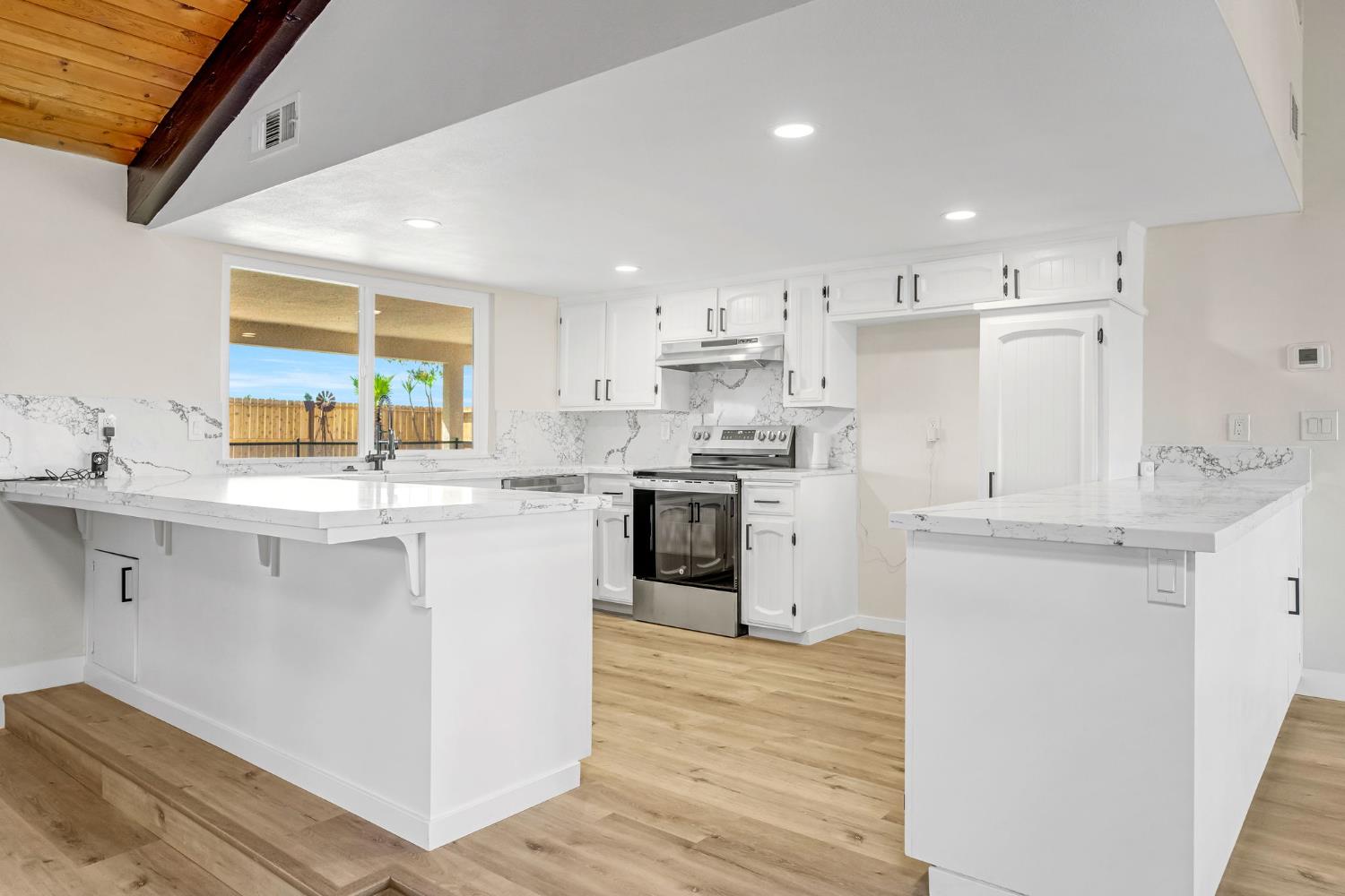 16860 Mark Road Madera, CA 93636 - Photo 10 of 44 a kitchen with stainless steel appliances white cabinets a sink a stove a refrigerator and a oven