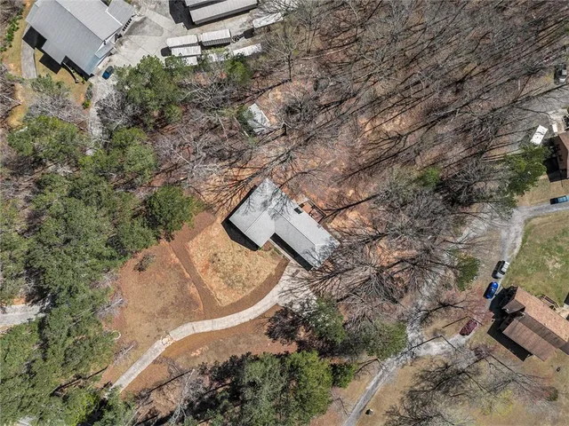 an aerial view of a house with a yard and greenery