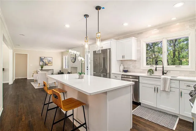 a kitchen with a dining table chairs sink and cabinets