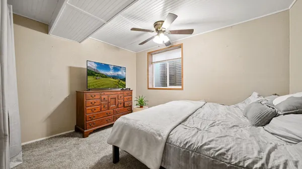 a bedroom with a bed and a flat screen tv