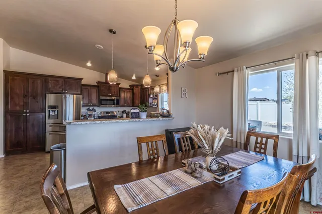a view of a dining room with furniture a chandelier and wooden floor