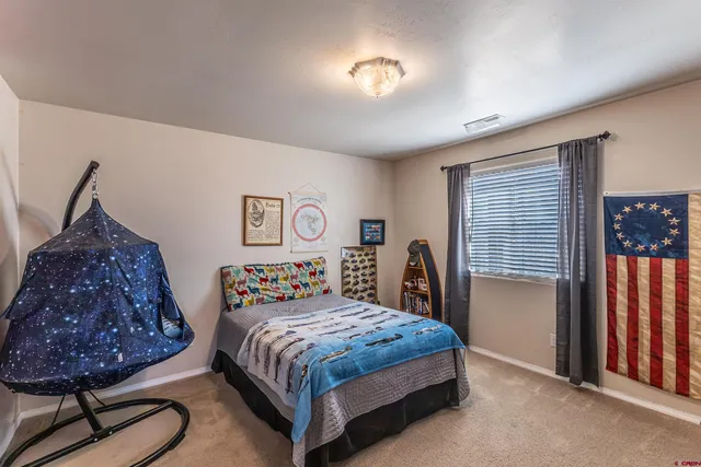 a bedroom with a bed and dresser with window