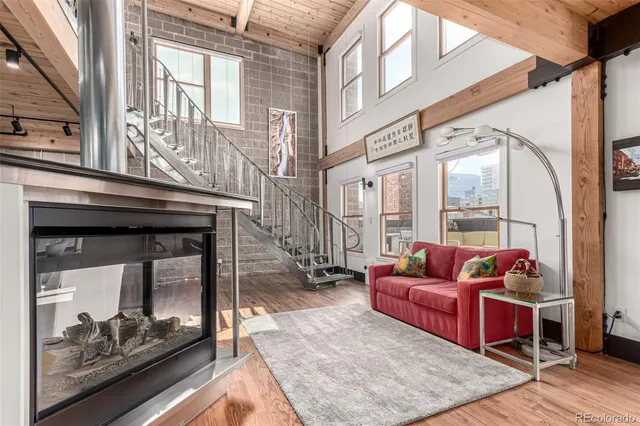 a living room with furniture a wooden floor and next to a window