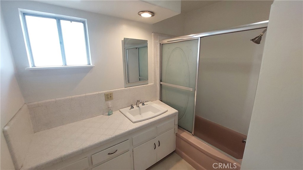 1909 Colusa Street Corning, CA 96021 - Photo 20 of 22 a bathroom with a shower sink and mirror
