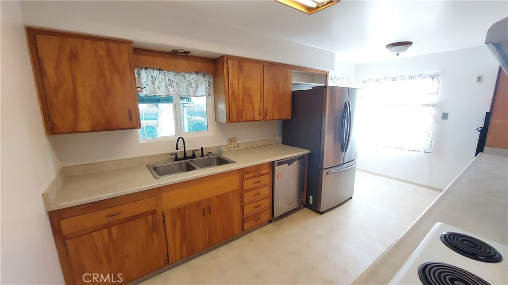 1909 Colusa Street Corning, CA 96021 - Photo 7 of 22 a kitchen with stainless steel appliances granite countertop a refrigerator a sink a stove a counter space and cabinets