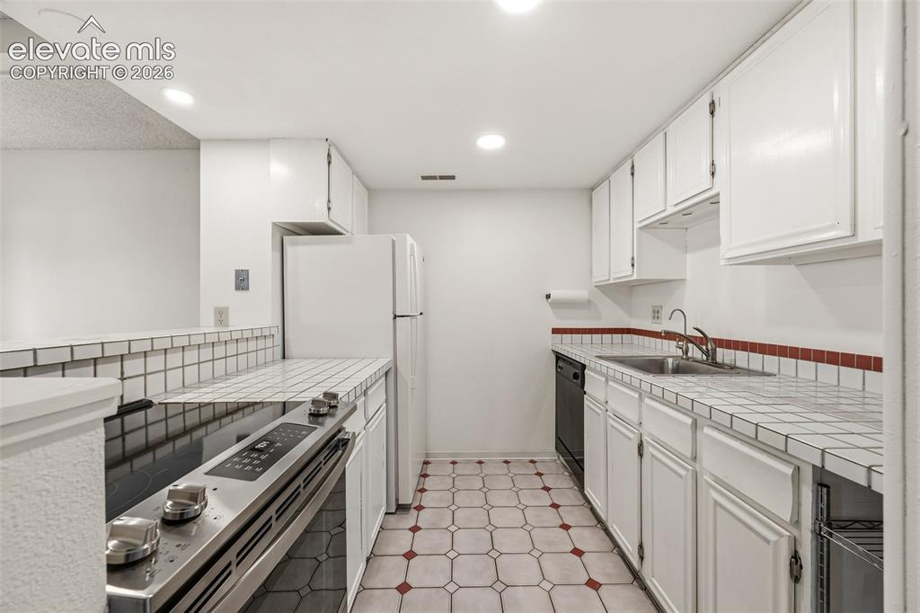 1018 Fontmore Road, Unit A Colorado Springs, CO 80904 - Photo 14 of 28 a kitchen with stainless steel appliances granite countertop a stove and a refrigerator