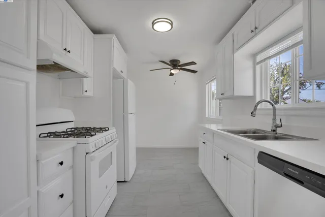 a kitchen with granite countertop a sink stove and cabinets