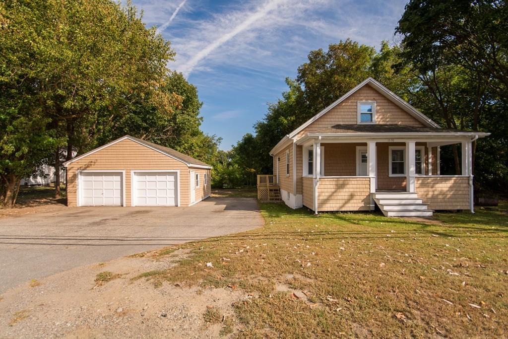 a front view of a house with a yard and trees