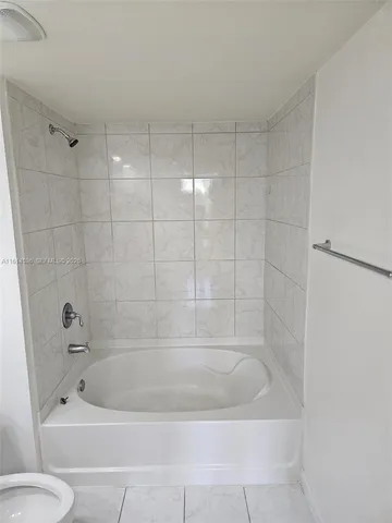 a bath tub sitting next to a white toilet and sink