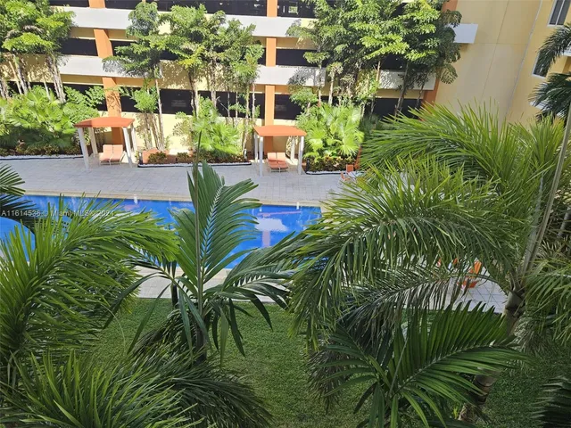 a living room with furniture a flat screen tv and kitchen view