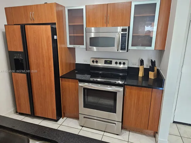 a kitchen with stainless steel appliances granite countertop a refrigerator stove and microwave