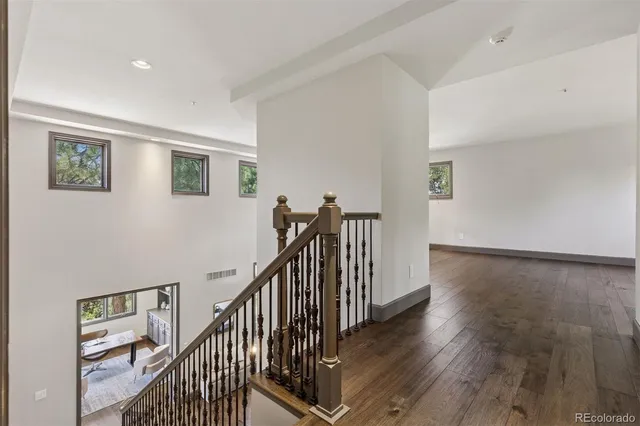 a view of a hallway with wooden floor and stairs