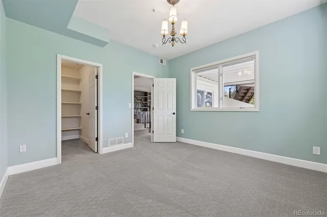 an empty room with chandelier and windows