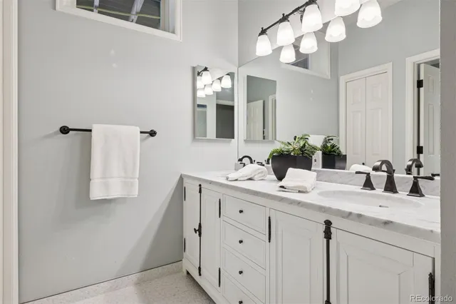 a bathroom with a sink vanity granite and a mirror