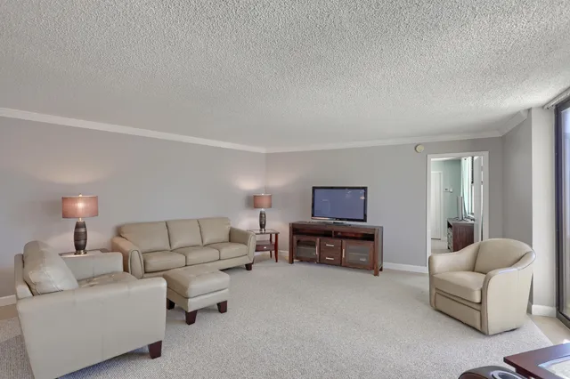 a living room with furniture and a floor to ceiling window