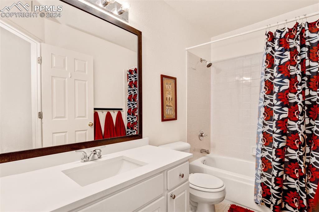 6385 Perfect View Colorado Springs, CO 80919 - Photo 22 of 35 Full Hall bathroom with shower / bathtub combination with curtain, vanity with extensive cabinet space, and toilet