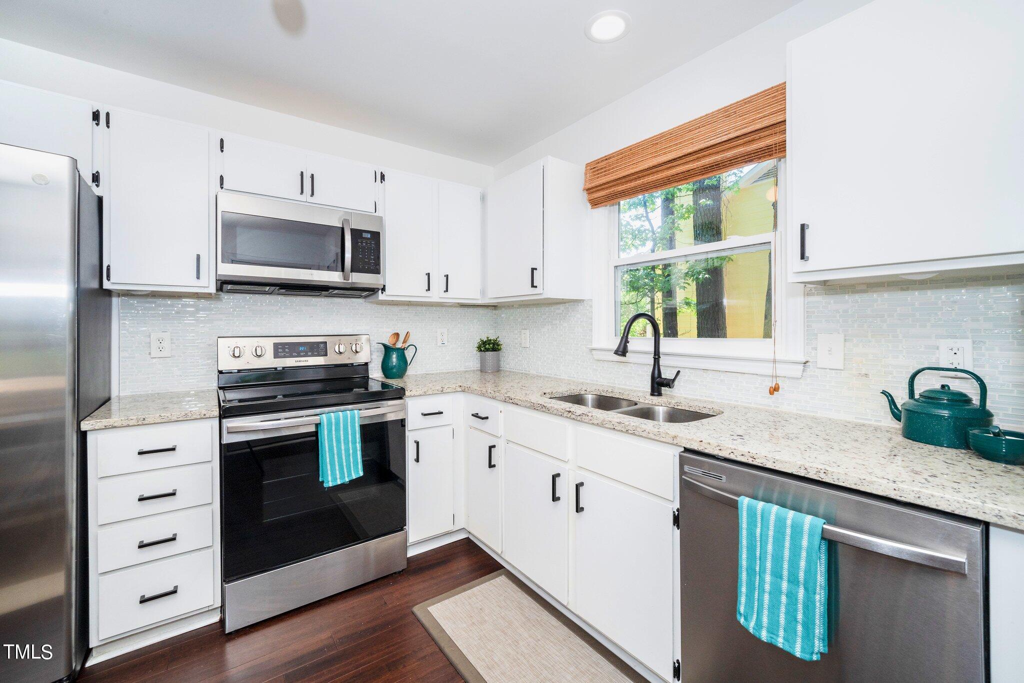 7 Little Spring Lane Durham, NC 27707 - Photo 12 of 25 a kitchen with stainless steel appliances granite countertop a sink stove and refrigerator