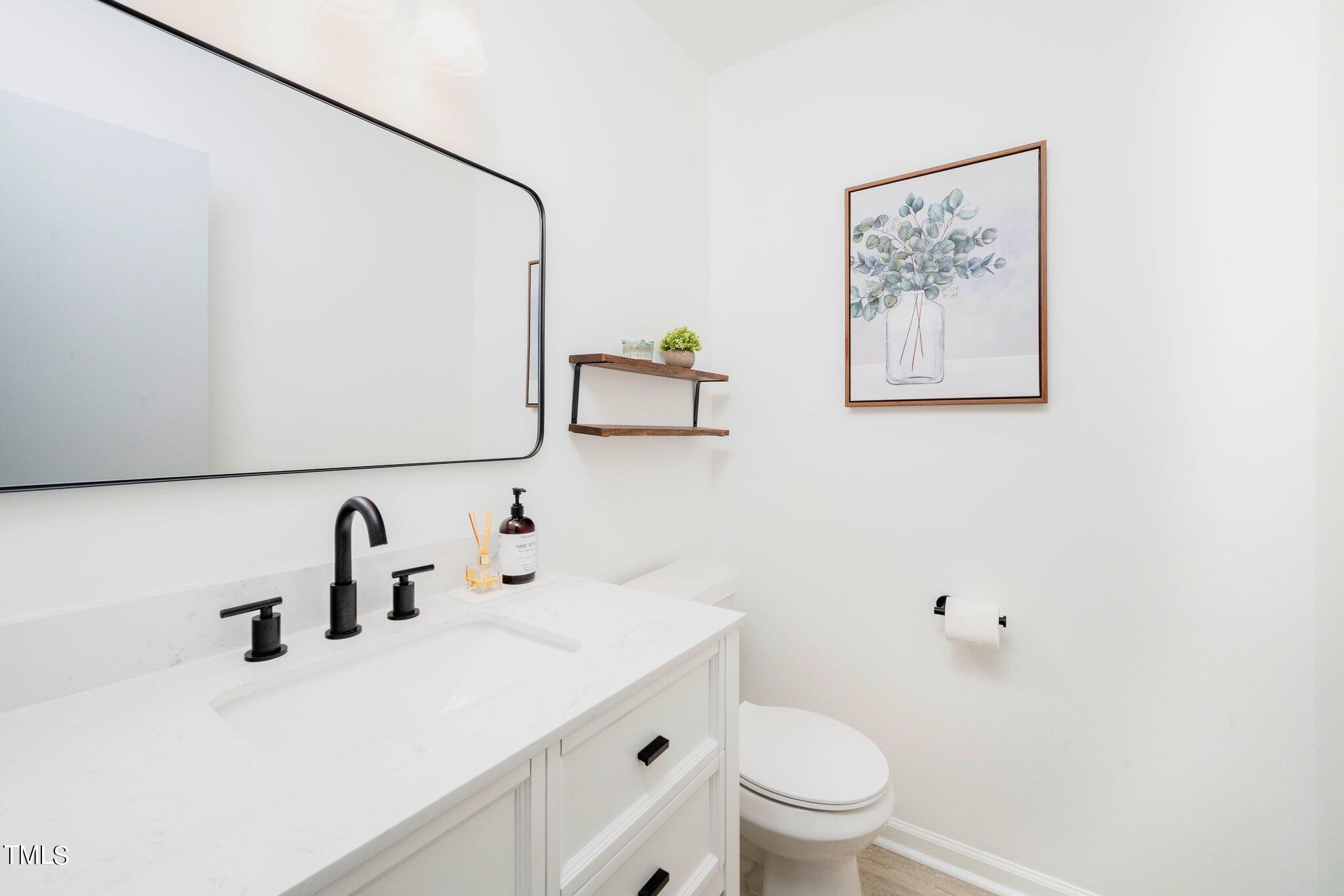 7 Little Spring Lane Durham, NC 27707 - Photo 16 of 25 a bathroom with a sink a toilet and a mirror