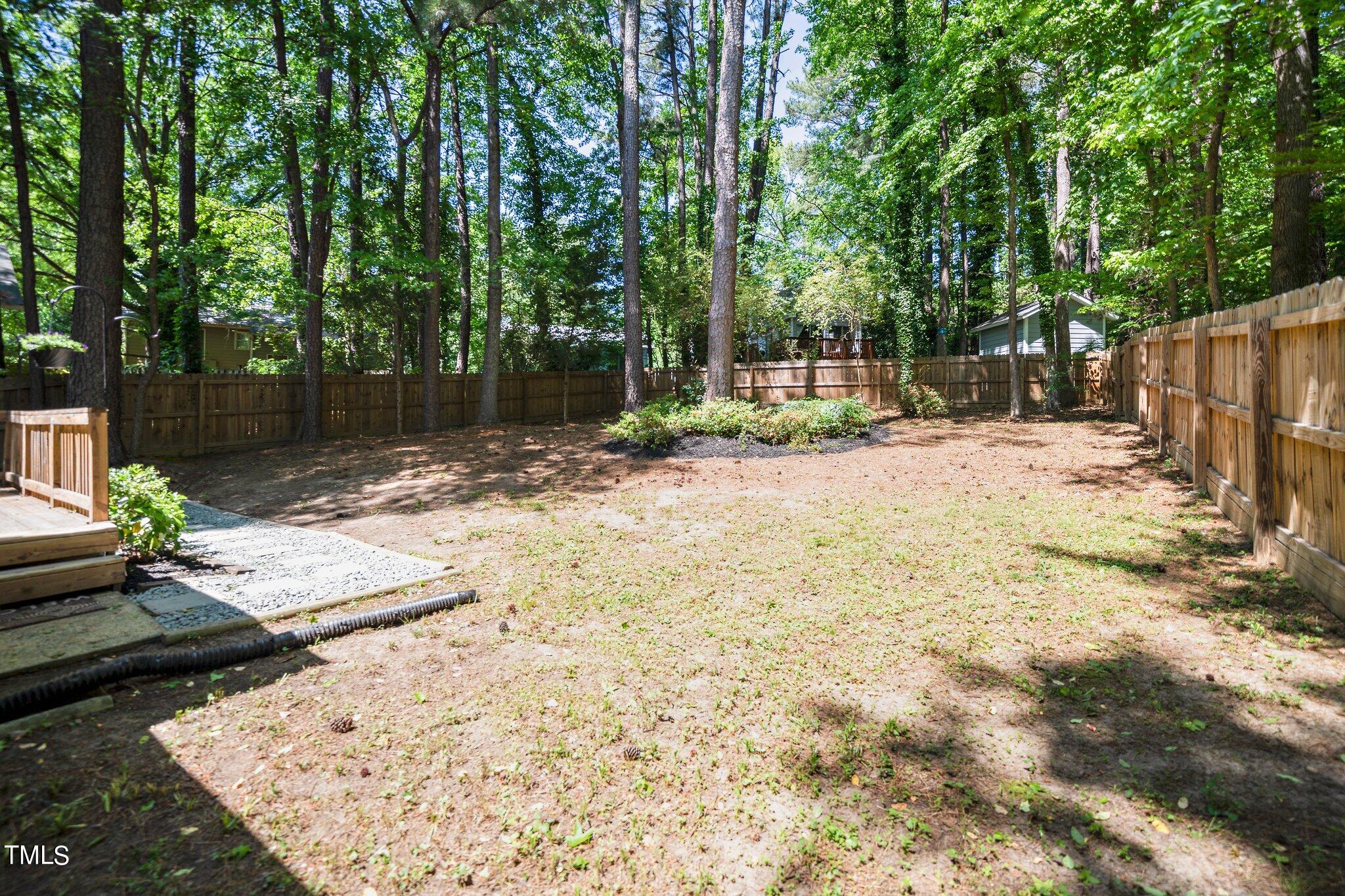 7 Little Spring Lane Durham, NC 27707 - Photo 21 of 25 a view of a backyard with wooden fence and a large tree