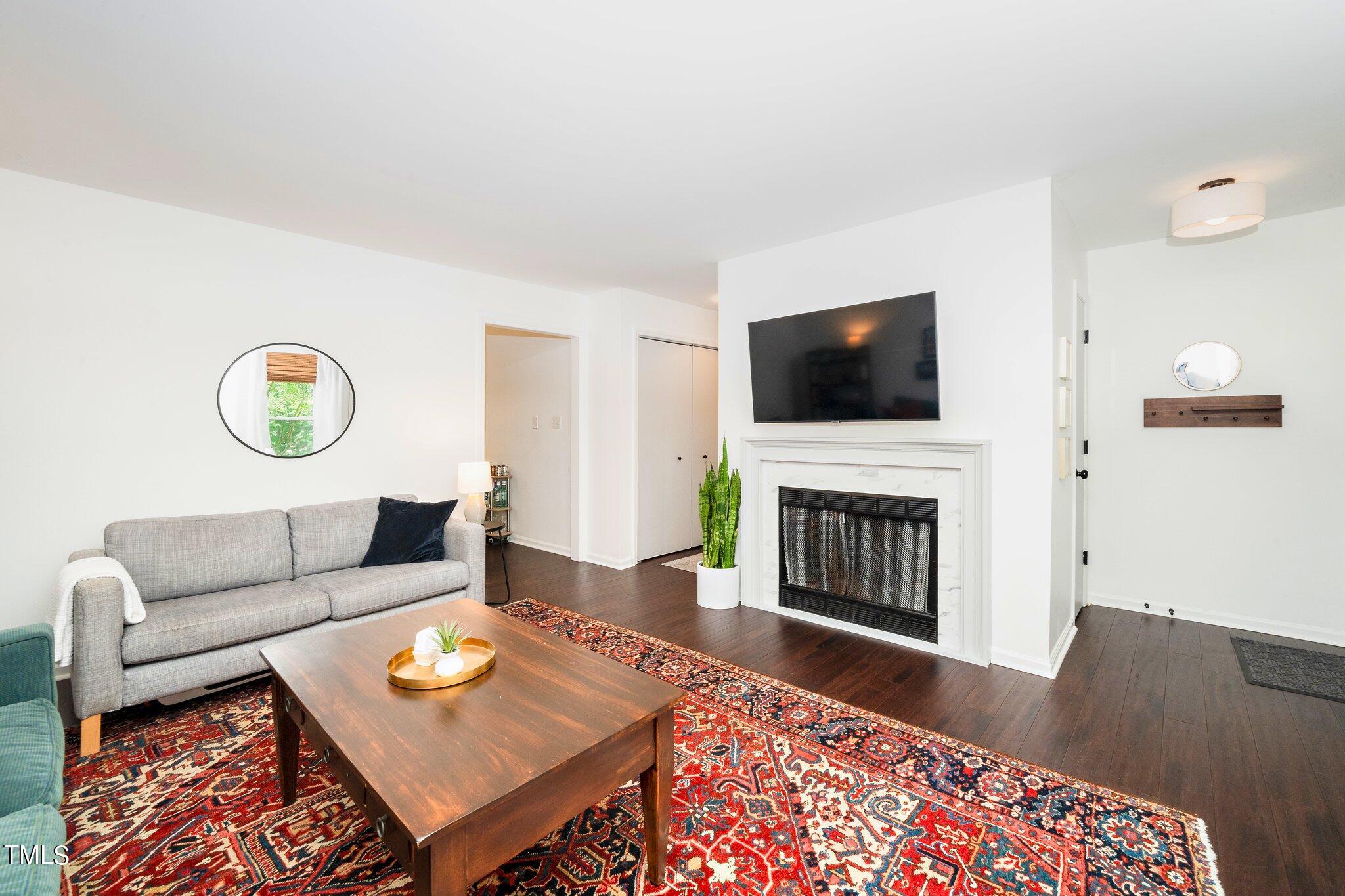 7 Little Spring Lane Durham, NC 27707 - Photo 6 of 25 a living room with furniture a fireplace and a flat screen tv