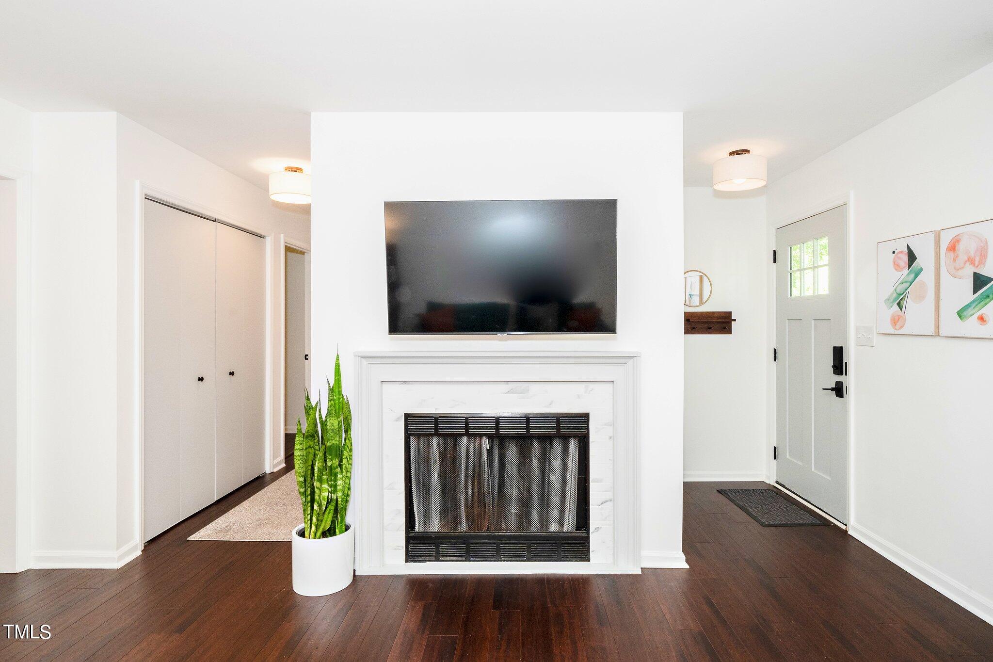 7 Little Spring Lane Durham, NC 27707 - Photo 7 of 25 a living room with a fireplace and a flat screen tv