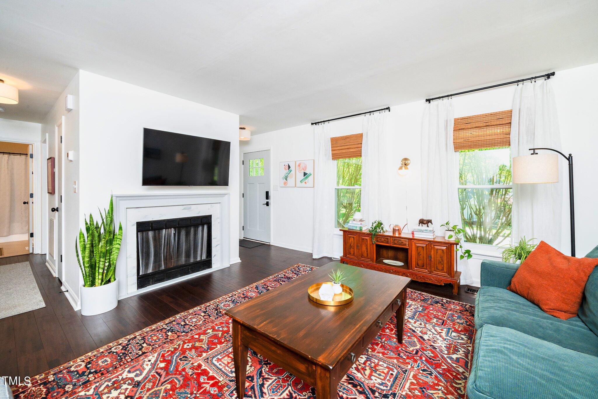 7 Little Spring Lane Durham, NC 27707 - Photo 8 of 25 a living room with furniture a fireplace and a flat screen tv