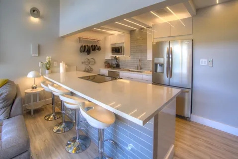 a room with wooden floor pool table and chairs