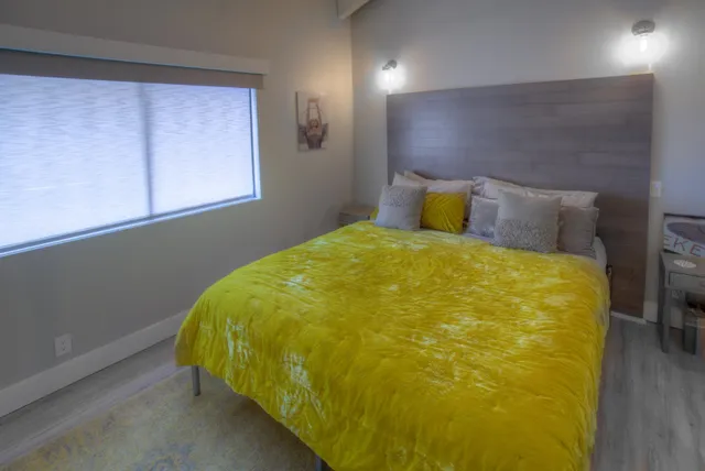 a bed sitting in a bedroom next to a window