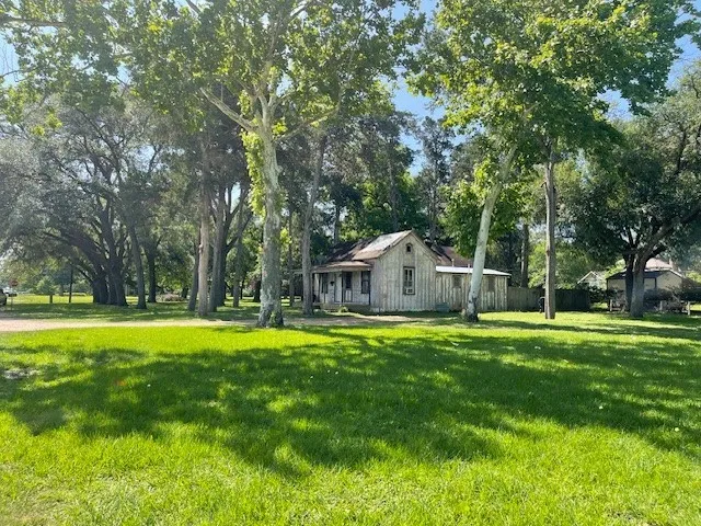 a front view of a house with a yard and trees