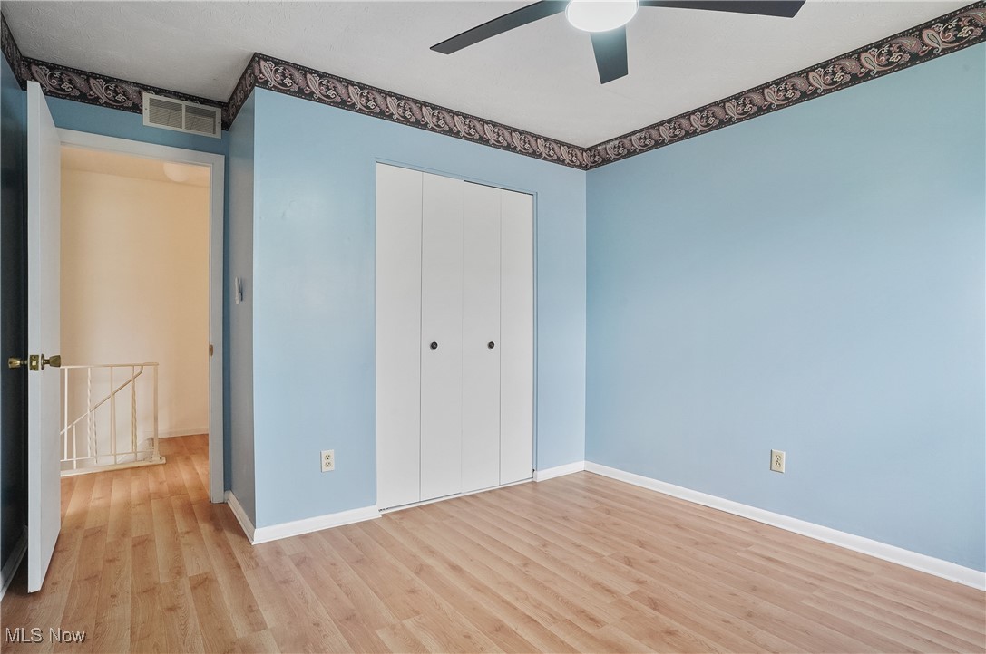 2500 Raber Road Uniontown, OH 44685 - Photo 24 of 31 Unfurnished bedroom featuring wood finished floors, visible vents, a closet, and baseboards