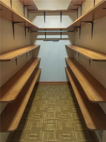 a view of an empty room with wooden floor and a fireplace