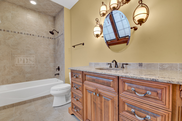 38W340 Henricksen Road St. Charles, IL 60175 - Photo 43 of 54 a bathroom with a granite countertop sink a toilet and a bathtub