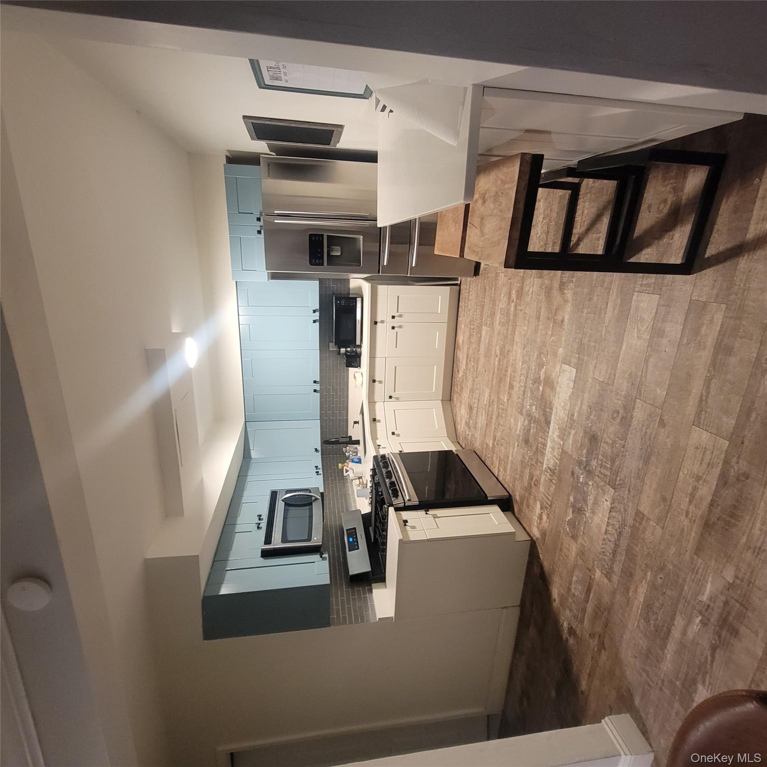 a kitchen with kitchen island a stove a microwave a sink a refrigerator and cabinetry