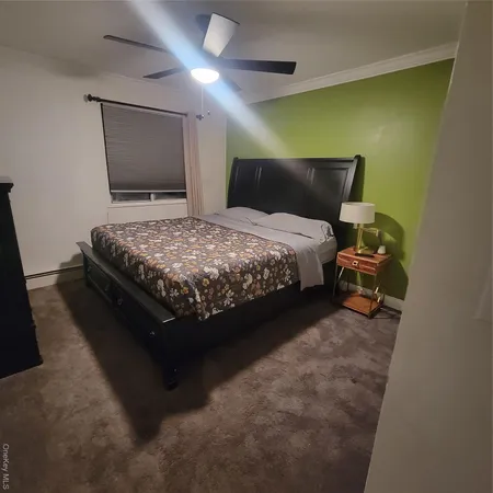 a bed sitting in a room next to a lamp