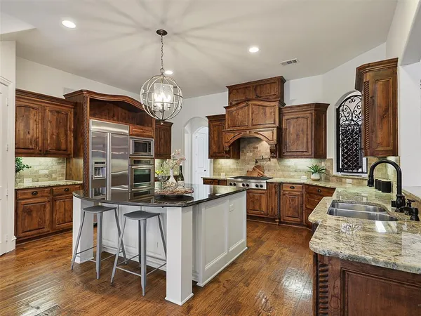 a kitchen with stainless steel appliances granite countertop a sink stove and refrigerator