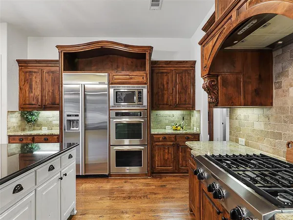 a kitchen with granite countertop a stove and a refrigerator