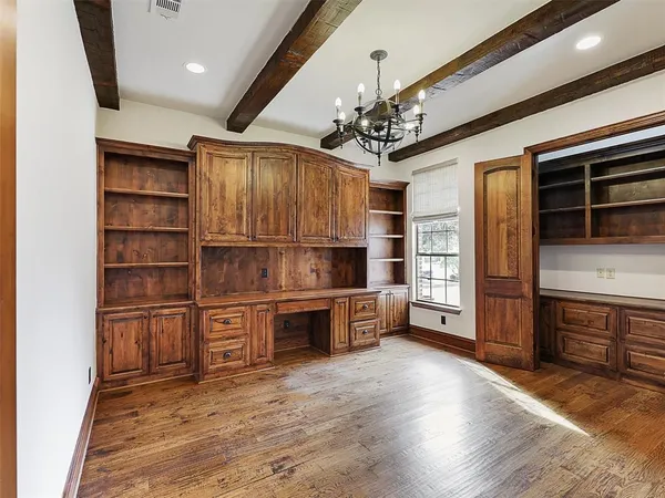 a kitchen with stainless steel appliances kitchen island granite countertop a refrigerator a stove and a oven with wooden floors