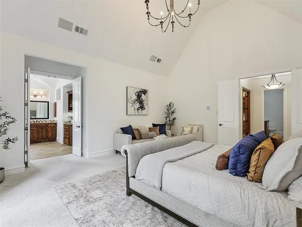 a bedroom with a bed and a chandelier