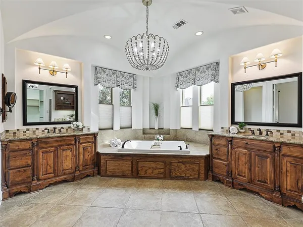 a spacious bathroom with a sink a large mirror and bathtub