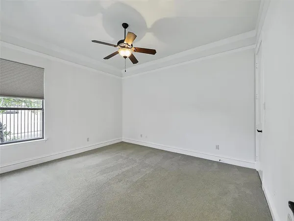 an empty room with a window and a ceiling fan
