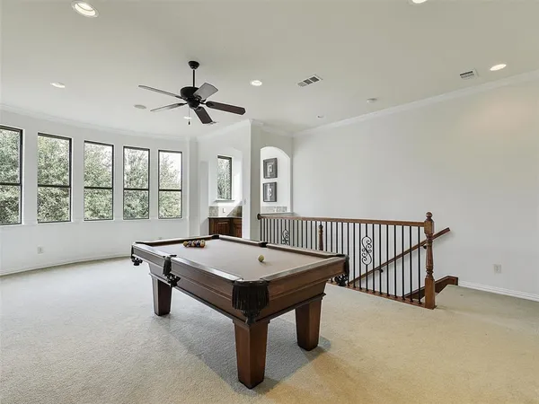 a room with pool table and windows