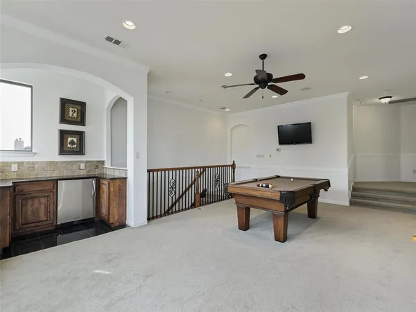 a living room with furniture a flat screen tv and a ceiling fan