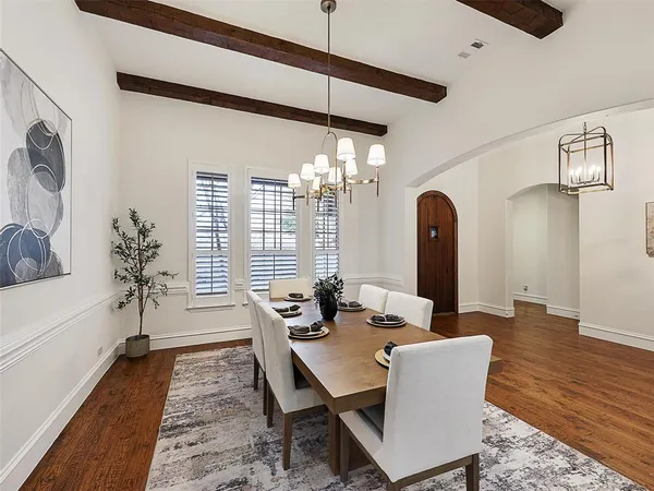 a dining room with furniture a chandelier and wooden floor